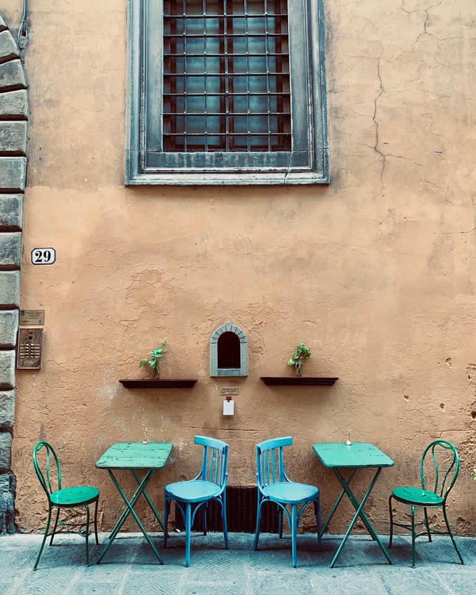 Buchetta del vino em fachada florentina com mesas e cadeiras coloridas